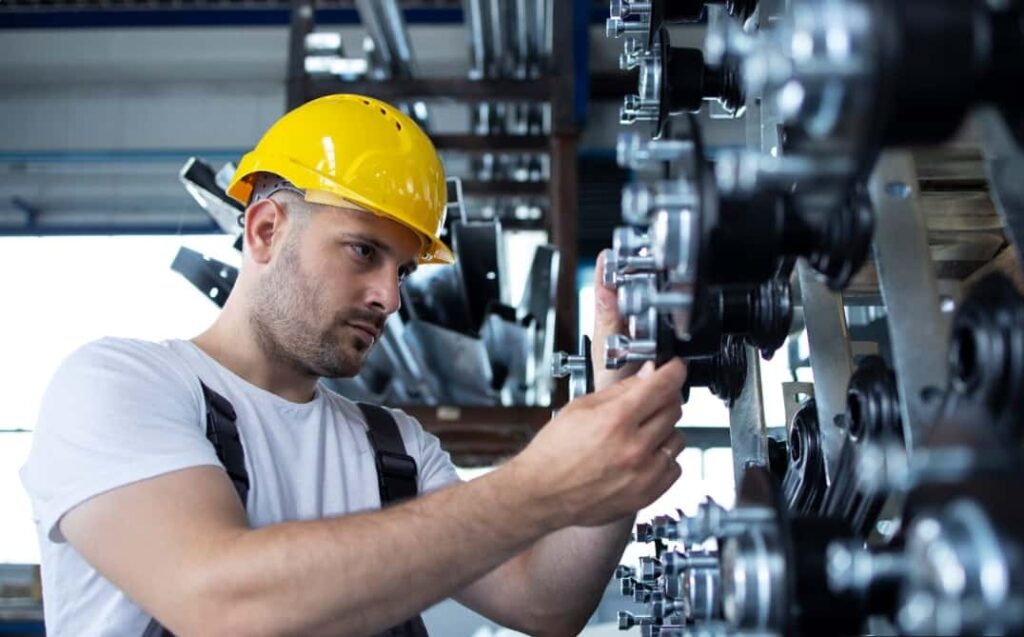 Technician upgrading industrial equipment with custom-engineered part