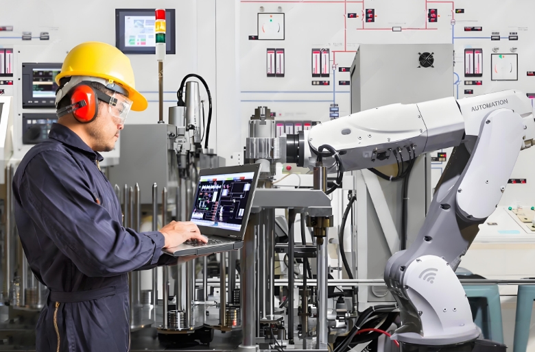 Technician operating CNC machine in factory, representing end-to-end manufacturing process